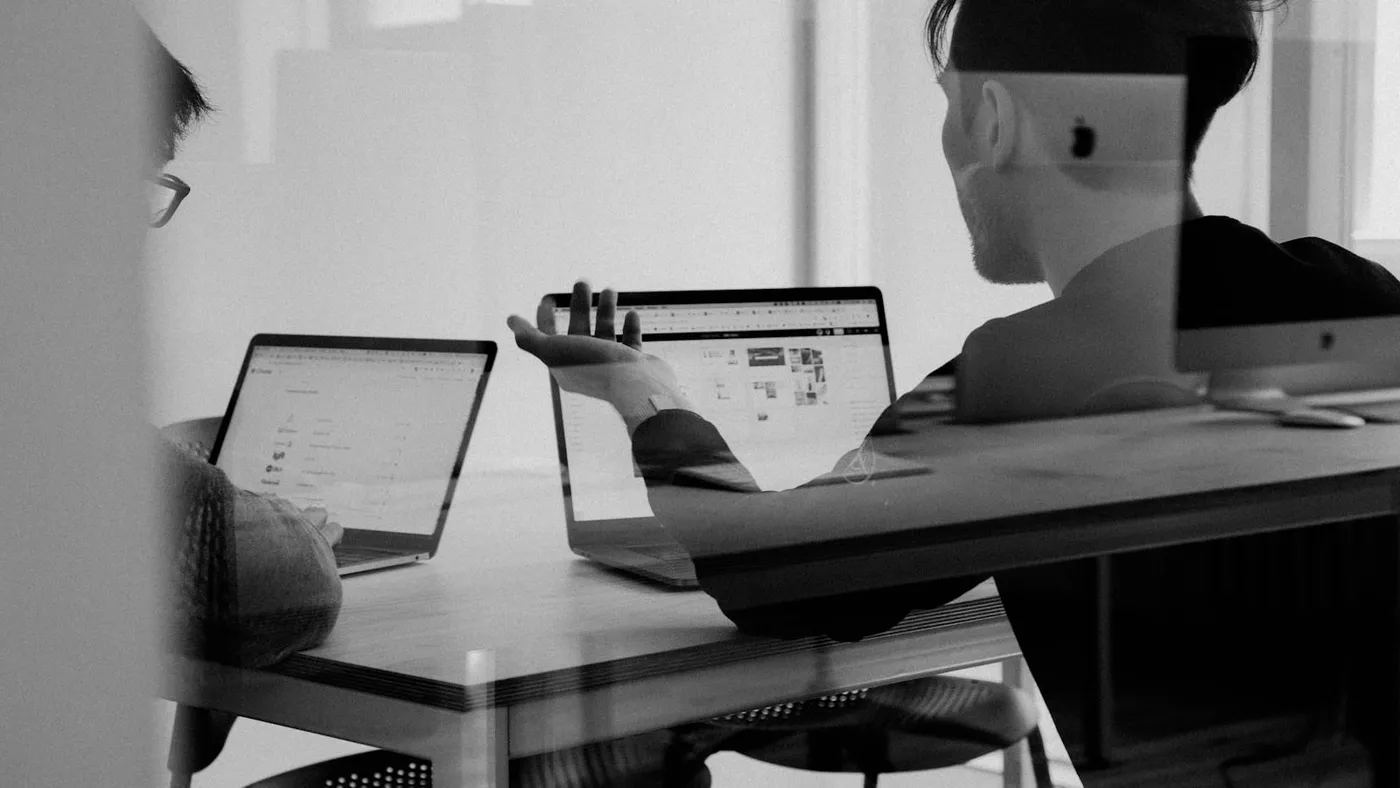 Fachperson vergleicht Portfolio-Beispiele von Agenturen am Laptop