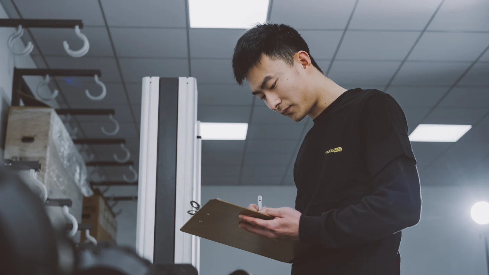 Worker scanning boxes and checking a clipboard during a stock count